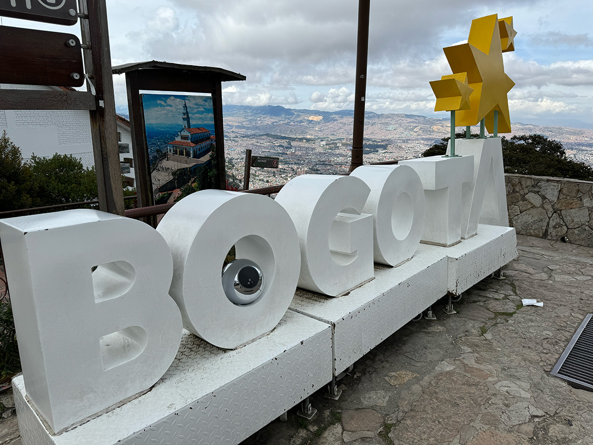 Colorful sign spelling 'BOGOTA' with a city view in the background