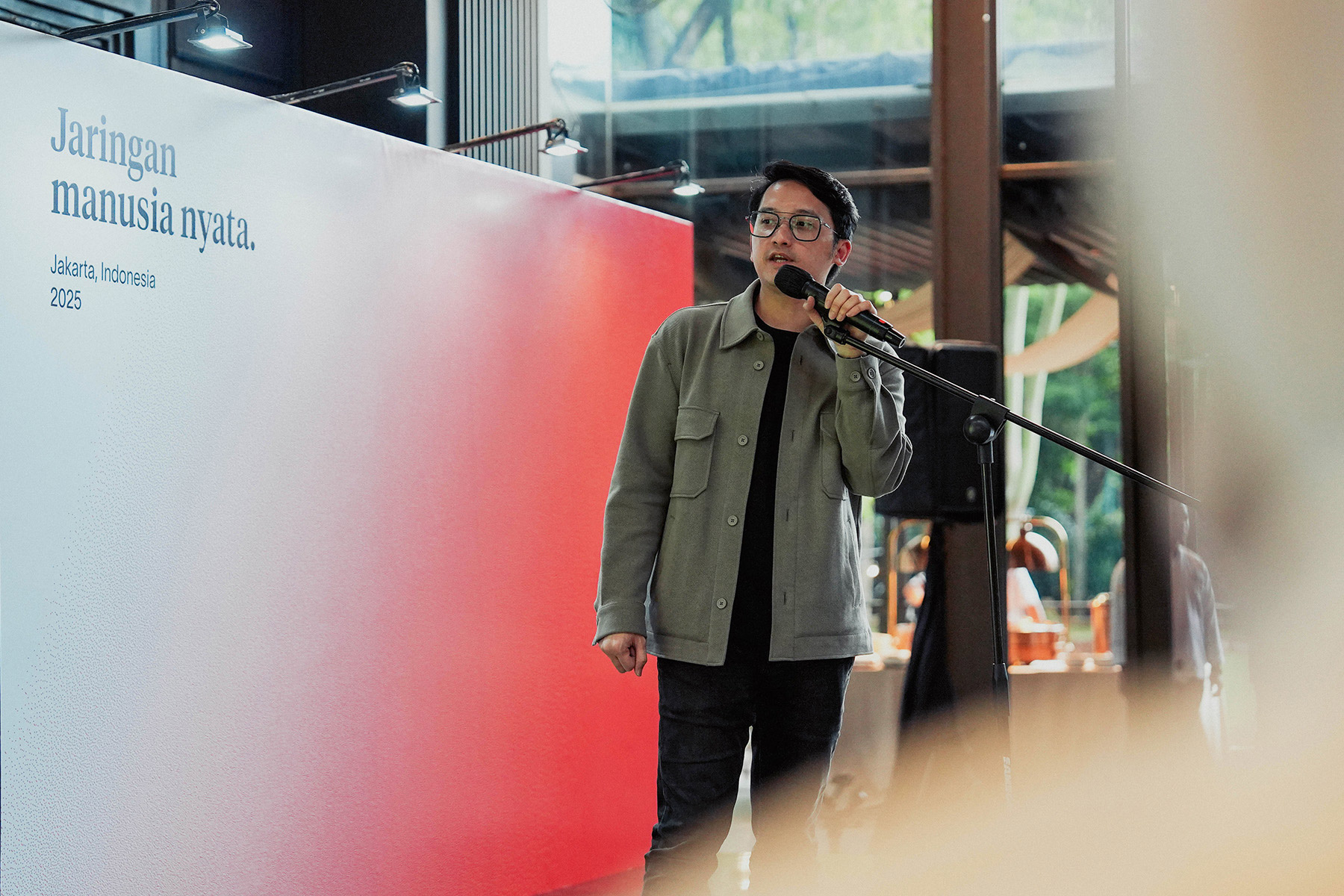 A speaker presenting at an event in Jakarta, Indonesia, discussing World ID verifications and digital transformation.