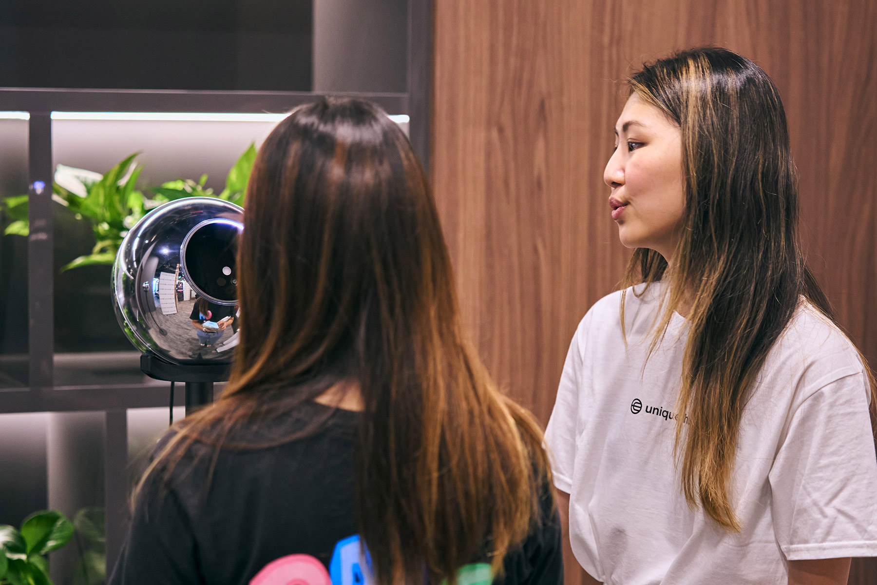 Two individuals engaging in a conversation while using the Orb for verification in a modern setting.