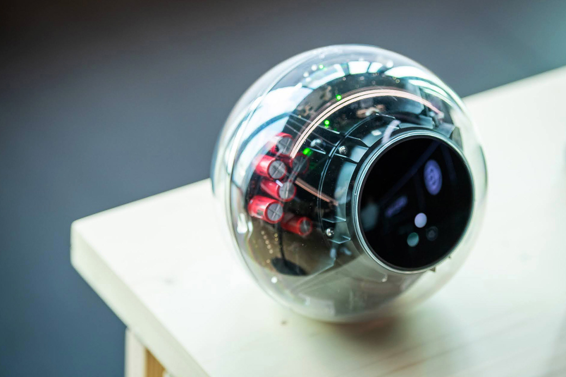 Close-up of the Orb, a biometric verification device with a transparent exterior exposing its inner components.